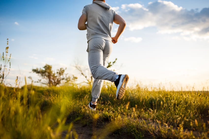 Close-up-of-sportive-man-jogging-in-field-at-sunrise.jpg
