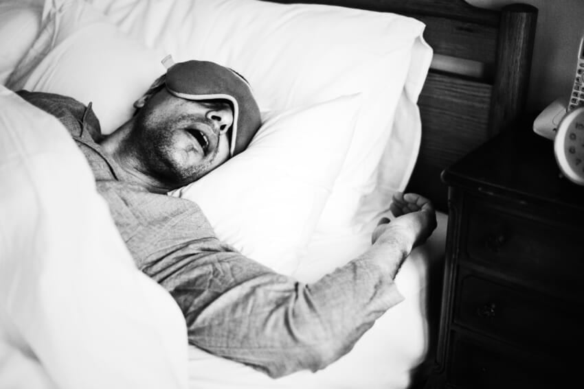 A-man-sleeping-on-a-bed.jpg