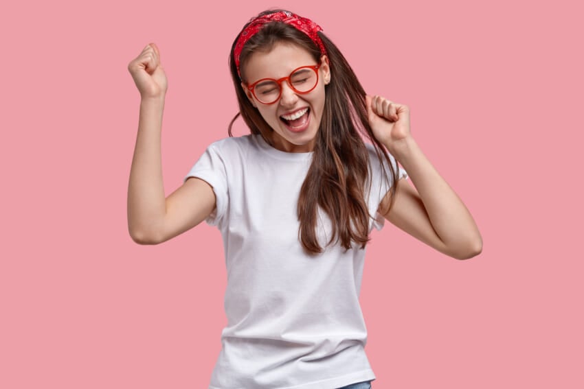 Triumphing-joyful-woman-clenches-fists-rejoices-positive-news-exclaims-gladfully-models-over-pink-space.jpg