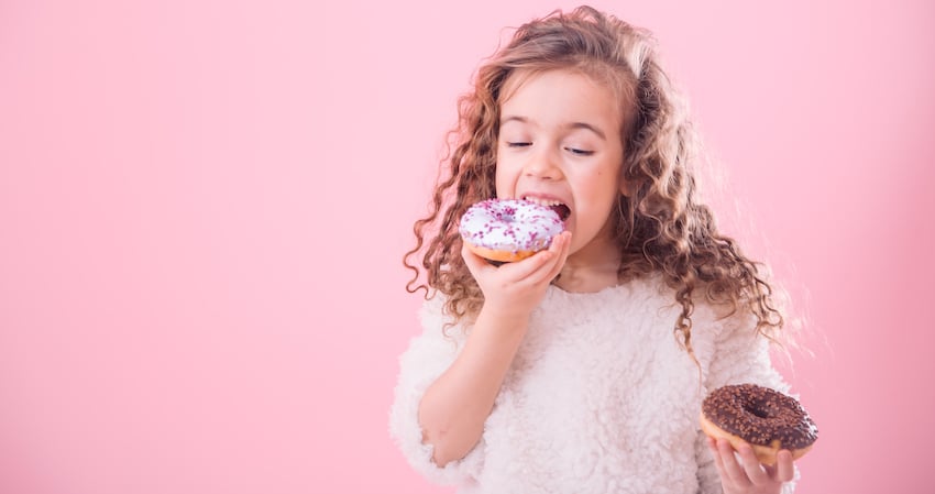 Portrait-of-a-little-curly-girl-eating-donuts.jpg