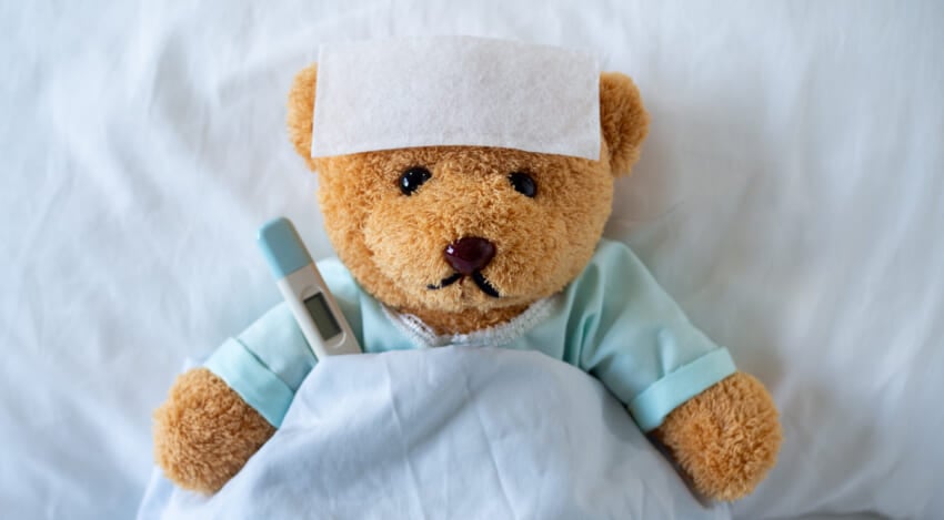The-teddy-bear-is-sick-on-the-bed-with-a-high-fever-there-is-a-fever-reducing-sheet-on-the-forehead.jpg