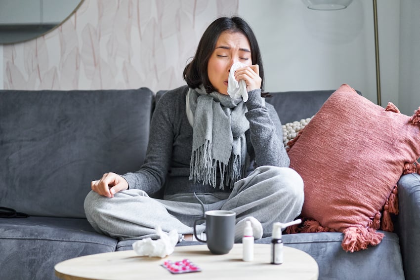 Portrait-of-korean-woman-sneezing-feeling-sick-staying-at-home-with-flu-or-cold-neck-wrapped-with-sc.jpg