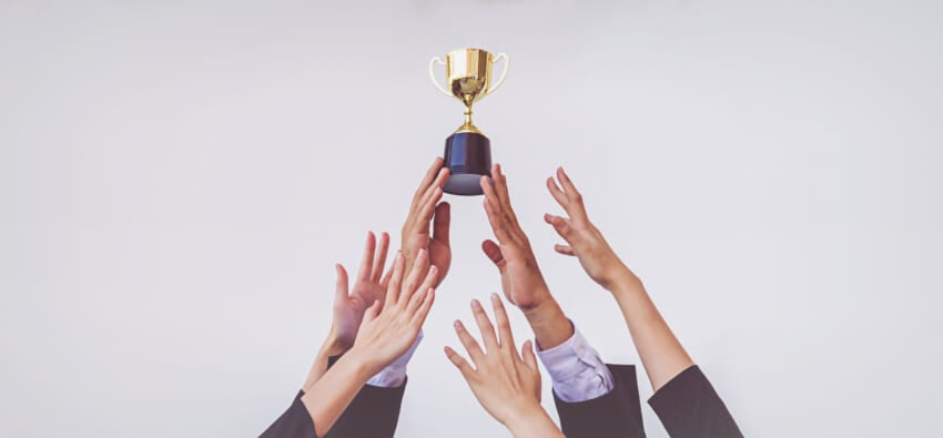 Hands-scramble-golden-trophy-cup-concept-business.jpg